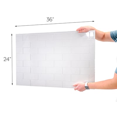 Person holding a 36x24 inch white subway tile shower wall panel showing its lightweight design and easy installation size