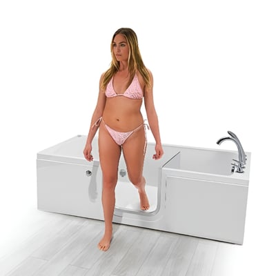 Woman in pink bikini stepping through the low-step side door entry of an Ella lay-down 32x72 walk-in tub
