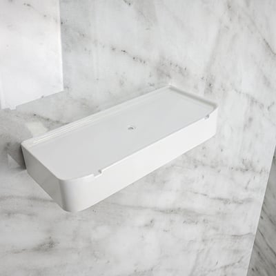 White acrylic soap dish accessory mounted on Carrara marble shower wall panel in an accessible shower stall