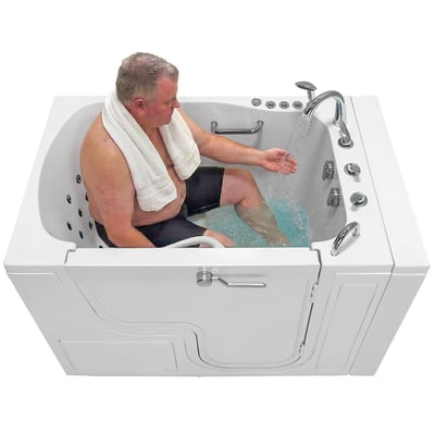 Man seated in a TransferXXL walk in tub as it fills, the wide transfer door latched shut at the front.