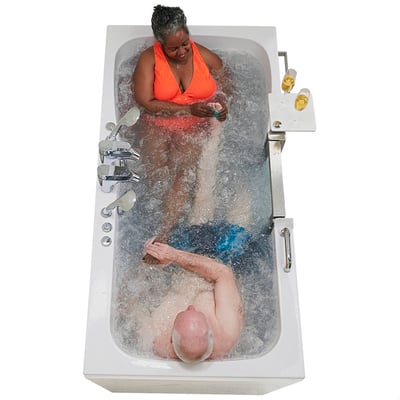 Two adults relaxing together in the Ella Escape two-seat walk-in tub enjoying air and hydro massage jets with a side tray