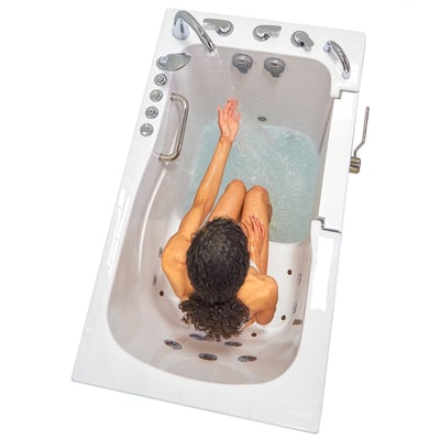 Woman reaching toward faucet while soaking in the Ella Capri walk-in tub with hydro jets and outward swing door