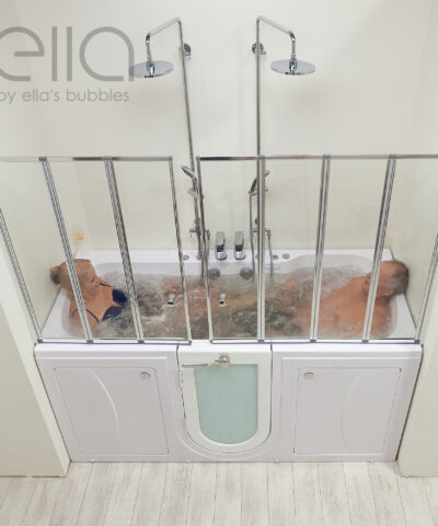 Senior couple relaxing in the Ella Big4Two two-seat walk-in tub with dual rain showerheads and hydro massage jets