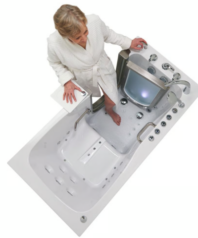 Woman standing in an Ella Ultimate walk in tub with LED chromatherapy light glowing through the tempered glass door