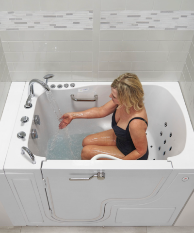 Woman seated in the Ella TransferXXL walk-in tub with 5 piece fast fill faucet running